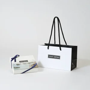 モノトーンカラーがカッコいいオリジナル紙袋とフルカラー印刷で「旅」を表現したオリジナルパッケージ